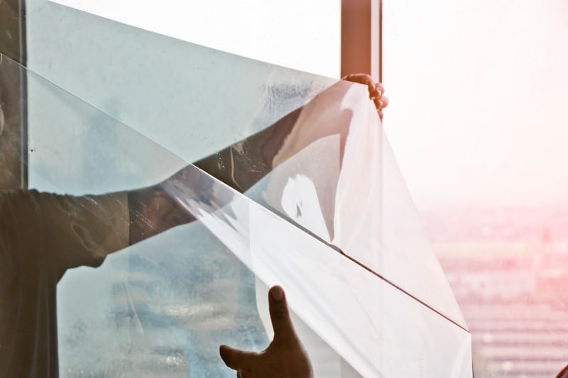 Tinted film being applied to glass